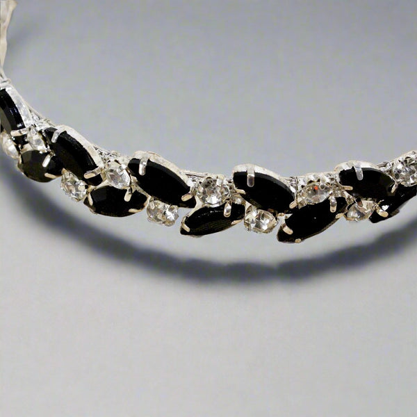 Necklace with black and clear gemstones on a light gray background