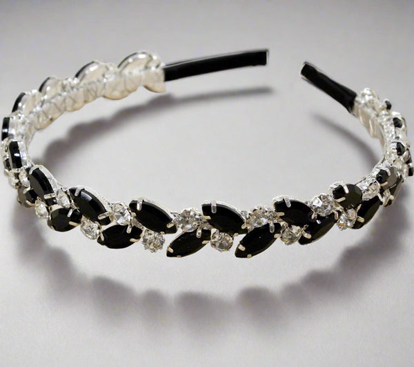 Decorative headband with black and clear gemstones on a gray background