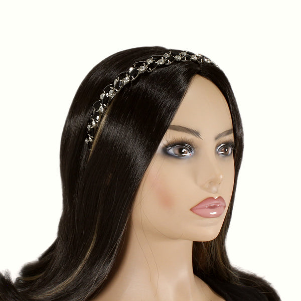 Mannequin head with long dark hair wearing a decorative headband on a white background