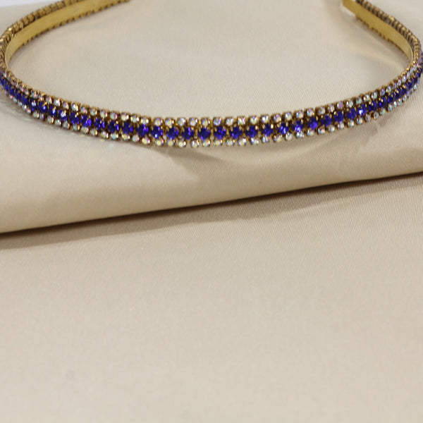 Gold headband with blue gemstones on a beige background