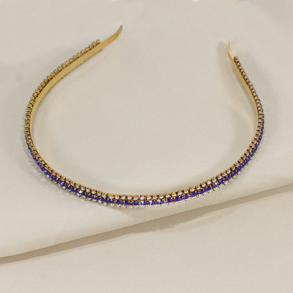 Gold headband with blue stones on a beige background