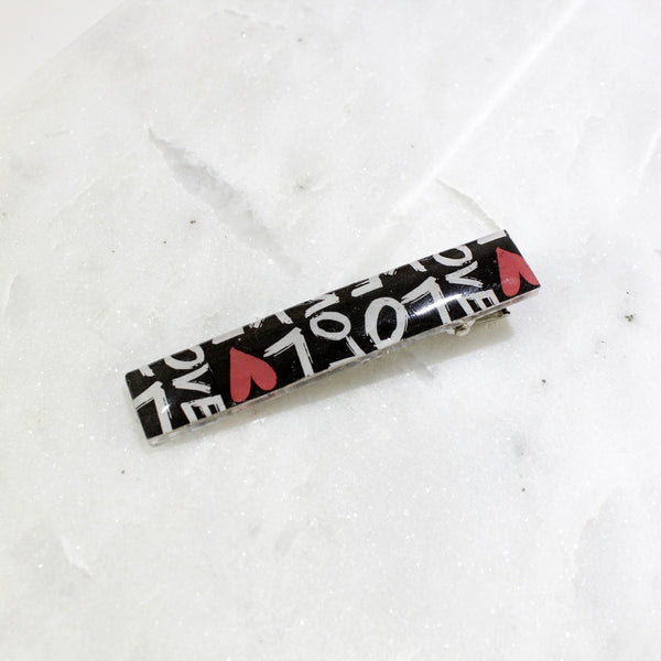 black with red hearts and white letters worlds love hair clip